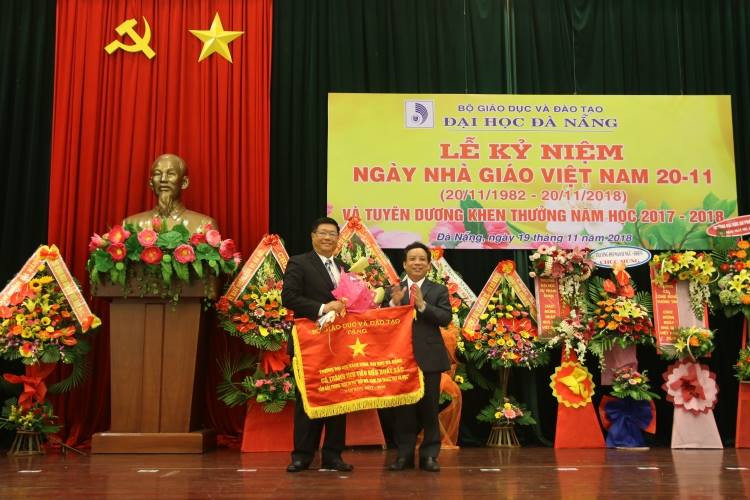 PGS.TS. Nguyễn Ngọc Vũ - Giám đốc ĐHĐN (bên trái) thừa ủy nhiệm của Bộ trưởng Bộ GD&ĐT trao Cờ thi đua của Bộ GD&ĐT cho Trường ĐH Bách khoa-ĐHĐN