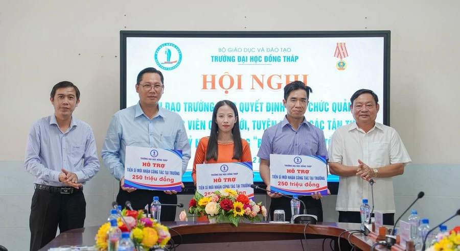 TS Trương Tấn Đạt - Chủ tịch Hội đồng trường (trái) và TS Hồ Văn Thống - Hiệu trưởng Trường ĐH Đồng Tháp trao hỗ trợ viên chức tuyển dụng mới có học vị tiến sĩ. Ảnh: NTCC