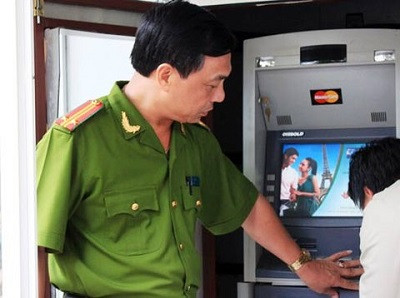 Cảnh sát giám sát việc lắp đặt hệ thống báo động tại cây ATM.