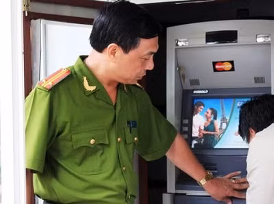 Cảnh sát giám sát việc lắp đặt hệ thống báo động tại cây ATM.
