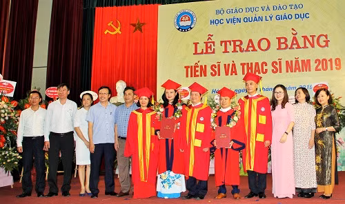 2 tân tiến sĩ chụp ảnh cùng Ban Giám đốc và các lãnh đạo phòng/ban, giảng viên Học viện