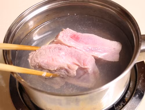 Không nên chần thịt qua nước đun sôi mà trước khi luộc nên ngâm thịt trong nước muối loãng. (Ảnh minh họa)