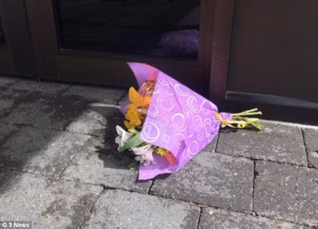 Một du khách đặt hoa bên ngoài vườn thú sau thảm kịch.