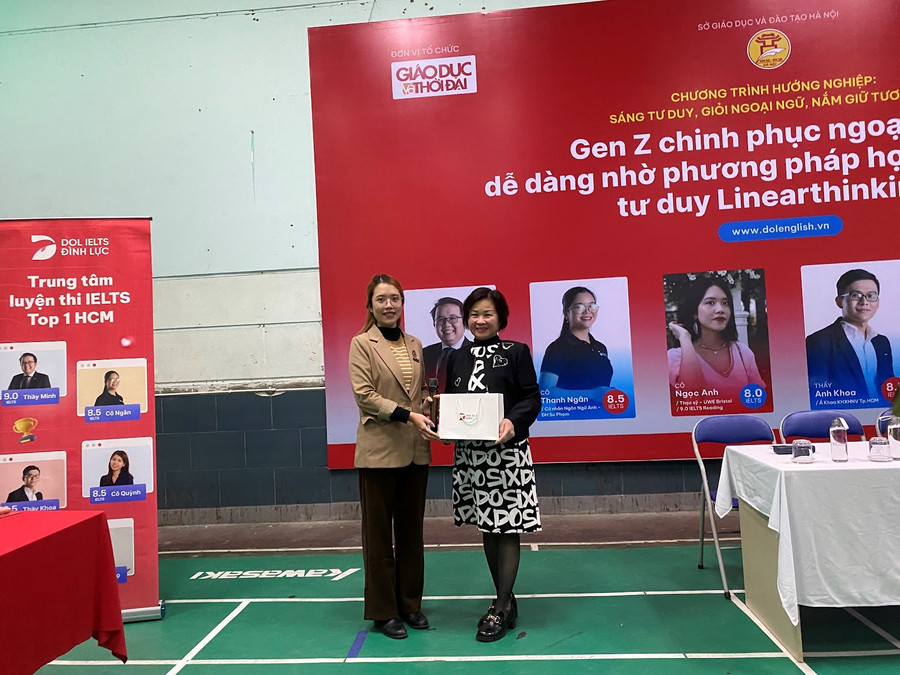 Cô Ngọc Anh - đại diện DOL IELTS Đình Lực gửi tặng món quà tới nhà trường.