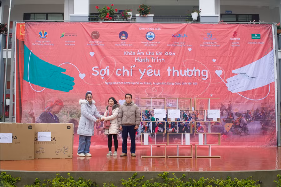 Bà Vũ Thương, Giám Đốc Sconnect Academy of Media Arts (bên trái) trao tặng tivi và tủ sách cho nhà trường.