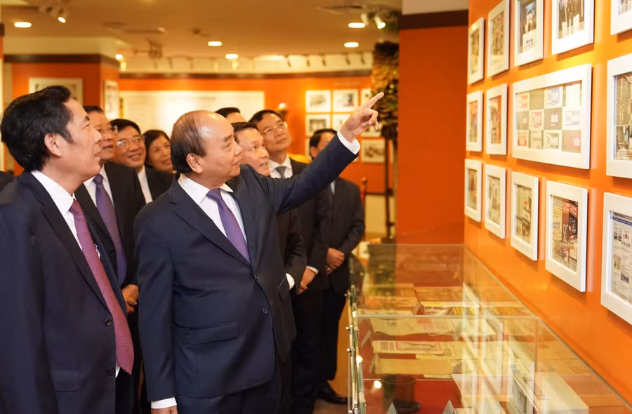 Thủ tướng Nguyễn Xuân Phúc và các đại biểu tham quan Phòng truyền thống của TTXVN. Ảnh: VGP/Quang Hiếu