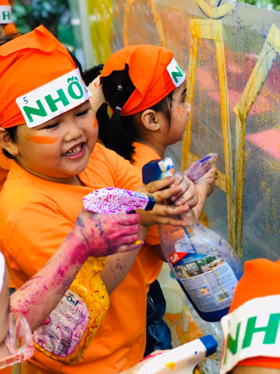 Trẻ được chơi tự do với màu và bình xịt tại khu vực Bạt màu.