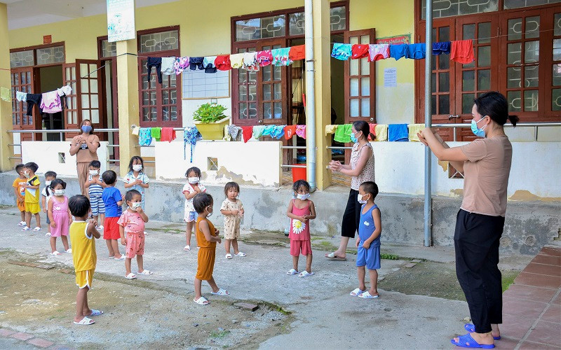 Cô giáo Trường Mầm non Mường Pồn (huyện Điện Biên) hướng dẫn học sinh tập thể dục và vệ sinh cá nhân trong khu cách ly.