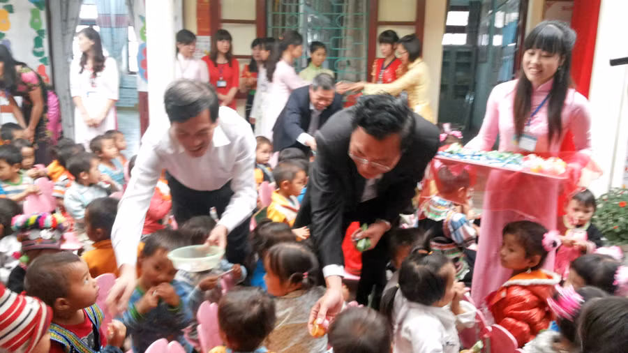 Bộ trưởng Phạm Vũ Luận cùng Phó Bí thư Thường trực Tỉnh ủy Lai Châu Đỗ Ngọc An chia kẹo cho các cháu học sinh