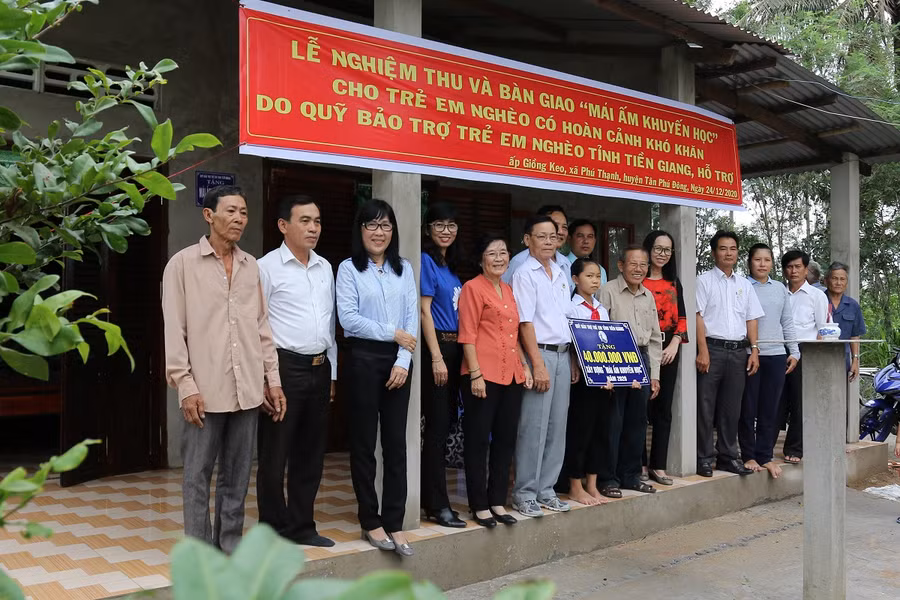 Các tổ chức, cá nhân chụp ảnh lưu niệm trước Mái ấm khuyến học của em Quỳnh Anh.