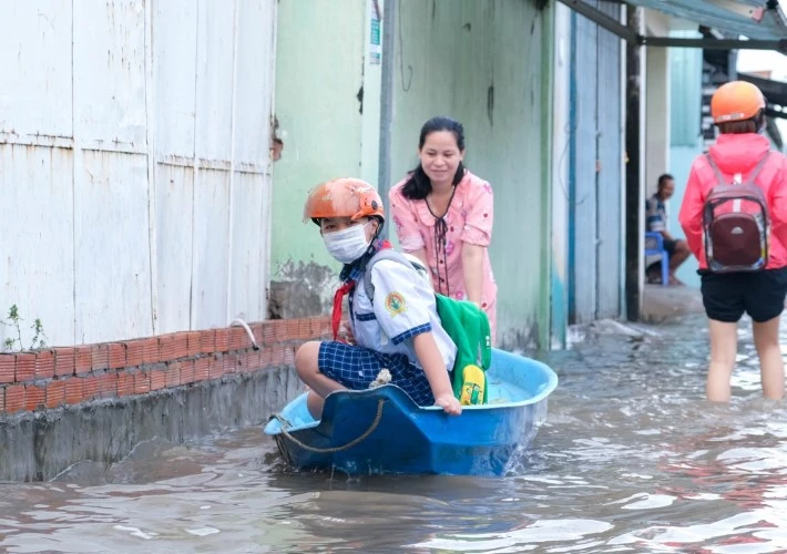 Phụ huynh ở TP Cần Thơ đưa HS đến trường bằng xuồng trong đợt triều cường sáng 20/10. Ảnh: Việt Hữu