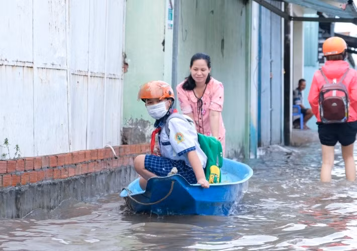 Phụ huynh ở TP Cần Thơ đưa HS đến trường bằng xuồng trong đợt triều cường sáng 20/10. Ảnh: Việt Hữu