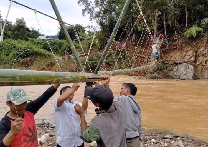 GV Trường Phổ thông Dân tộc Bán trú Tiểu học Tr’Hy và người dân địa phương làm cầu tạm nối giữa hai thôn Abanh 1 và Abanh 2. Ảnh: Hà Nguyên
