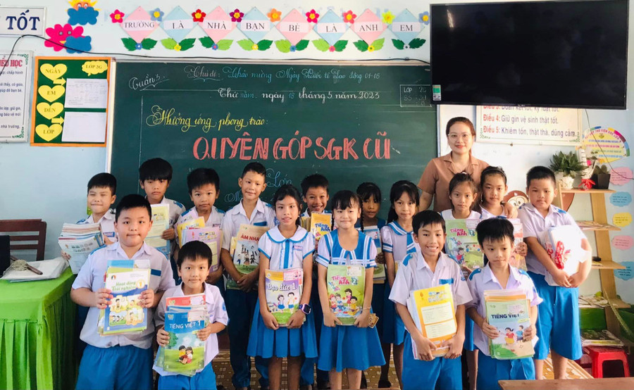 Học sinh khối lớp Một, Trường Tiểu học Nghĩa Lộ được cô giáo hướng dẫn cách sử dụng, bảo quản sách giáo khoa để có thể tái sử dụng cho những năm sau.