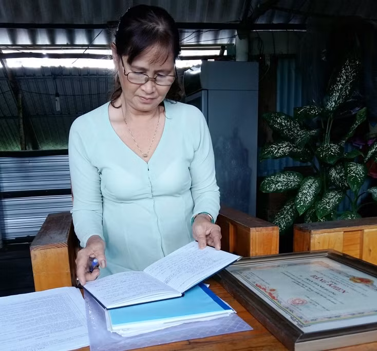 Chị Trần Thanh Hương - Phó Chủ nhiệm CLB xem danh sách những gia đình có hoàn cảnh bệnh tật, khó khăn để giúp đỡ