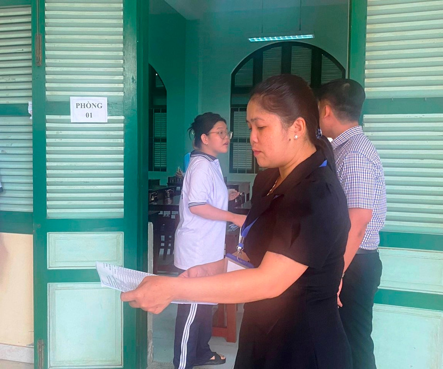 Cán bộ coi thi gọi thí sinh vào phòng thi.