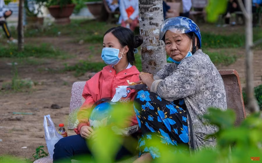 Hai bà cháu bà Phan Thị Thau đến điểm nhận quà từ sớm.