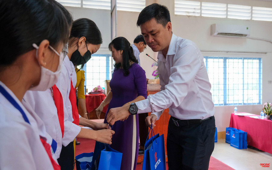 Đại diện Công ty Cổ phần xuất nhập khẩu Bình Tây (Bitex) trao quà cho các em học sinh.