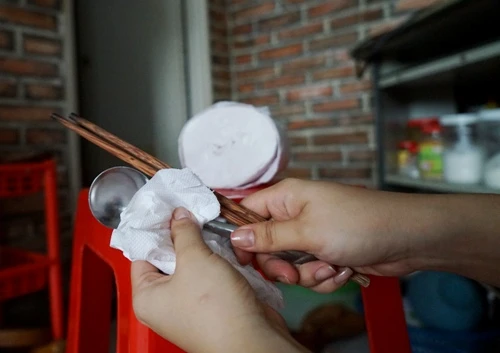 Dùng giấy vệ sinh lau chén, đũa tiềm ẩn nhiều nguy cơ gây hại đến sức khỏe. Ảnh: Thi Ngoan.