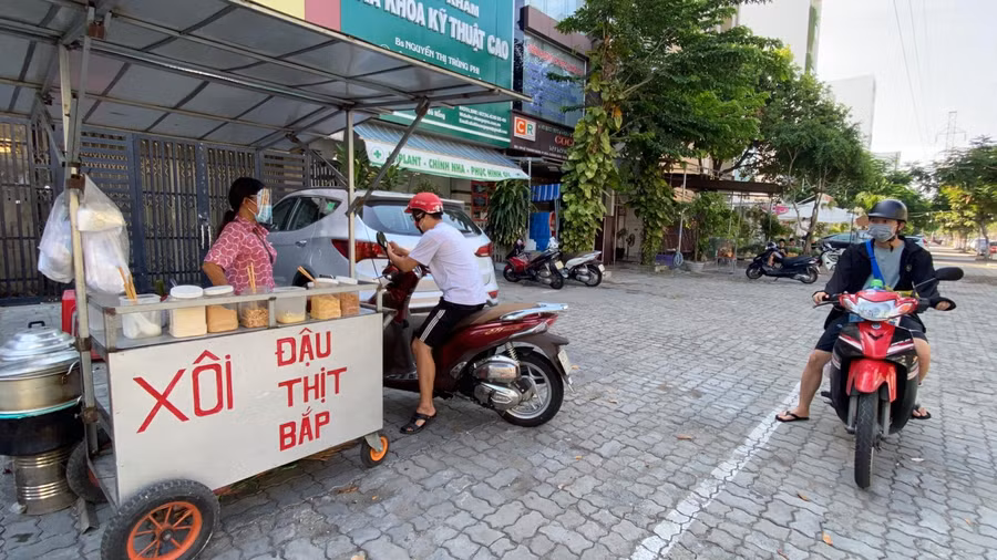 Người bán hàng đeo tấm chắn giọt bắn trong lúc bán hàng.