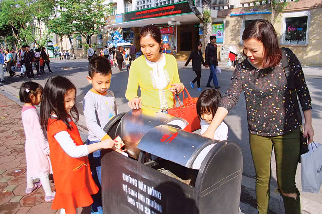 Vứt rác đúng quy định là điều trẻ cần học khi tới nơi công cộng. Ảnh minh họa.