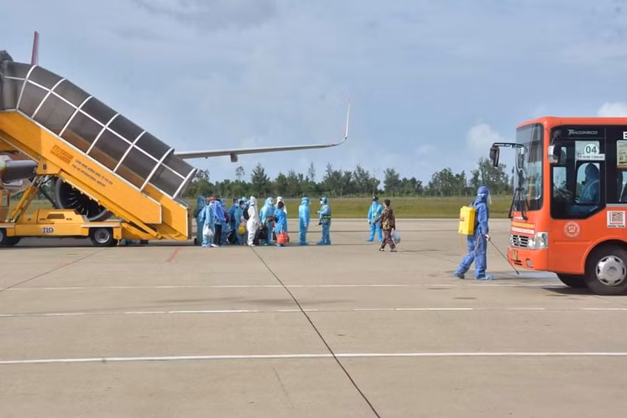 Lực lượng chức năng phun khử khuẩn sau khi công dân xuống sân bay.