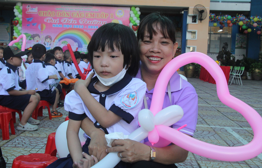 Giáo viên Trường Tiểu học Nguyễn Thanh Tuyền dỗ dành học sinh ngày tựu trường.