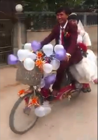 Cảnh rước dâu bằng xe đạp điện của đôi bạn trẻ xứ Nghệ. Ảnh: Cắt từ clip.