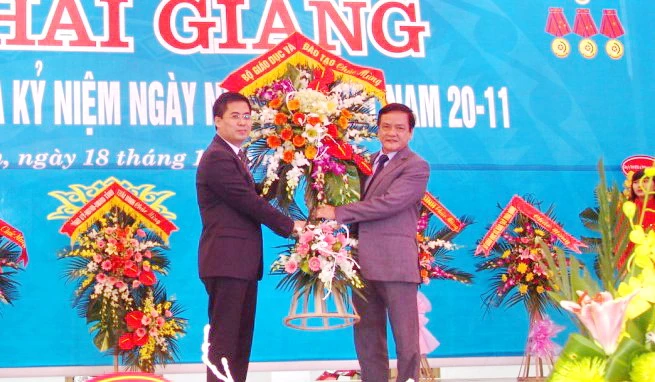 Chánh Văn phòng Bộ GD&ĐT Phạm Ngọc Phương (bên phải) tặng hoa chúc mừng nhà trường