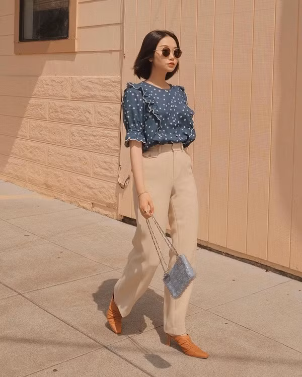 Set đồ vừa nữ tính vừa thanh lịch của Vivid Wu rất phù hợp cho các quý cô công sở. Blogger thời trang nước Mỹ này đã mix áo blouse chấm bi cổ điển cùng quần âu cạp cao và giày cao gót. Cách sơ vin gọn gàng vừa mang đến sự chỉn chu, lịch sự vừa giúp cô tạo được một bộ trang phục hack dáng thành công.