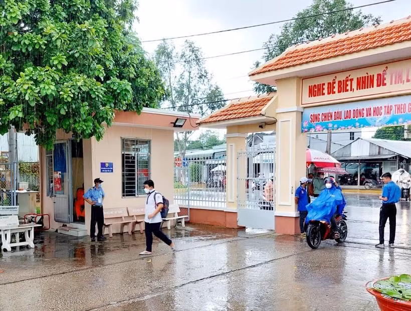 Thí sinh đội mưa đến điểm thi.