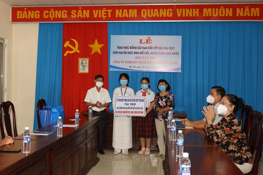 Trao học bổng và quà tặng cho 2 em.