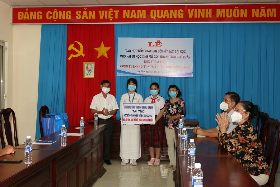 Trao học bổng và quà tặng cho 2 em.