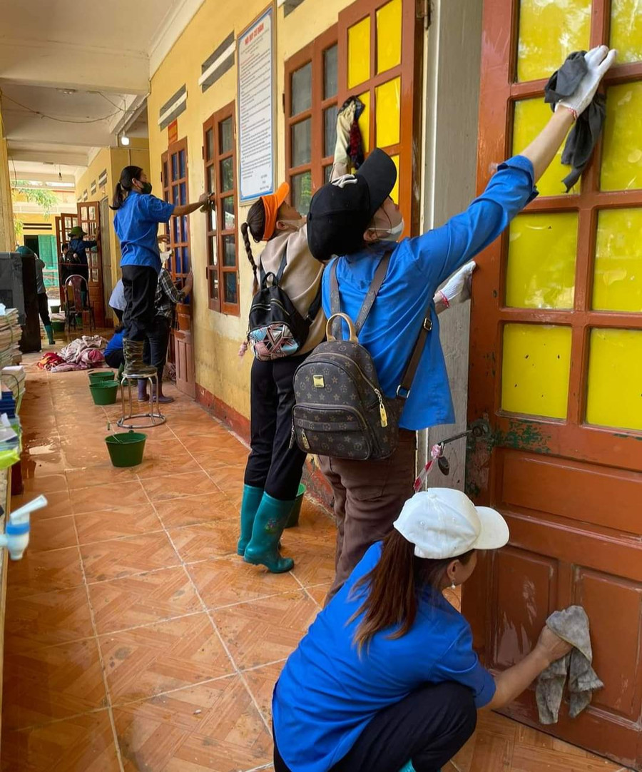 Giáo viên dọn vệ sinh sau lũ. Ảnh: NTCC