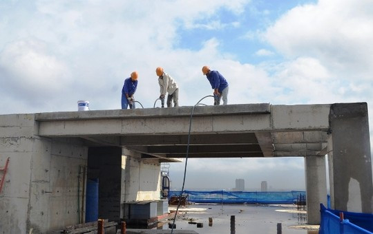 Chủ đầu tư bắt đầu phá dỡ phần xây dựng sai phép của tòa nhà 8B Lê Trực vào sáng 21/11/2015 với việc “cắt ngọn” tầng tum song tiến độ phá dỡ sau đó rất chậm. Ảnh: Nguyễn Hưởng