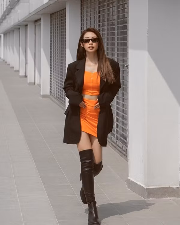 Diện nguyên set đồ màu cam rực rỡ với blazer cá tính không chỉ giúp Khổng Tú Quỳnh khoe được eo thon, dáng nuột mà còn tạo cho cô vẻ sành điệu, sang chảnh. Đôi boots da cao quá gối góp phần tăng vẻ chất chơi cho cô nàng.