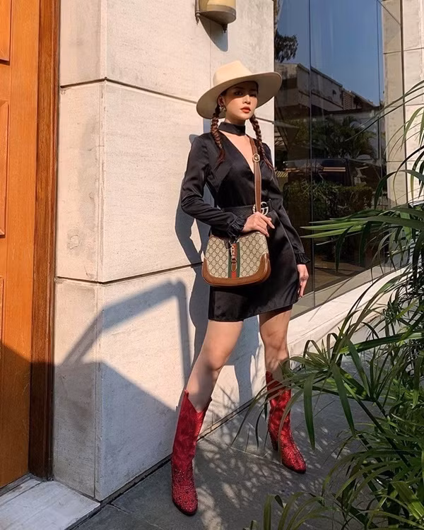 Chi Pu thả dáng kiêu kỳ trong chiếc đầm đen, chít eo duyên dáng. Loạt phụ kiện như mũ vành rộng, boots cao cổ và túi Gucci giúp cô hóa thân thành nữ cao bồi cá tính.