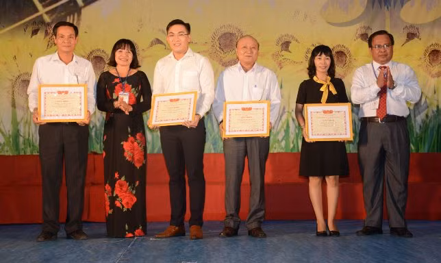 Giám đốc Sở GD& ĐT Cà Mau Nguyễn Minh Luân (phải) và Chủ tịch Công đoàn Ngành GD Cà Mau Đặng Thùy Phương (áo dài) trao giấy khen cho đơn vị, trường học đạt giải A và xuất sắc toàn đoàn