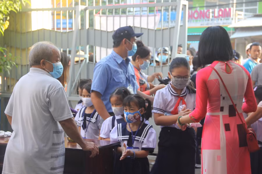 Ngay từ sớm học sinh đã có mặt. Các em được yêu cầu đo thân nhiệt, rửa tay sát khuẩn trước khi vào trường