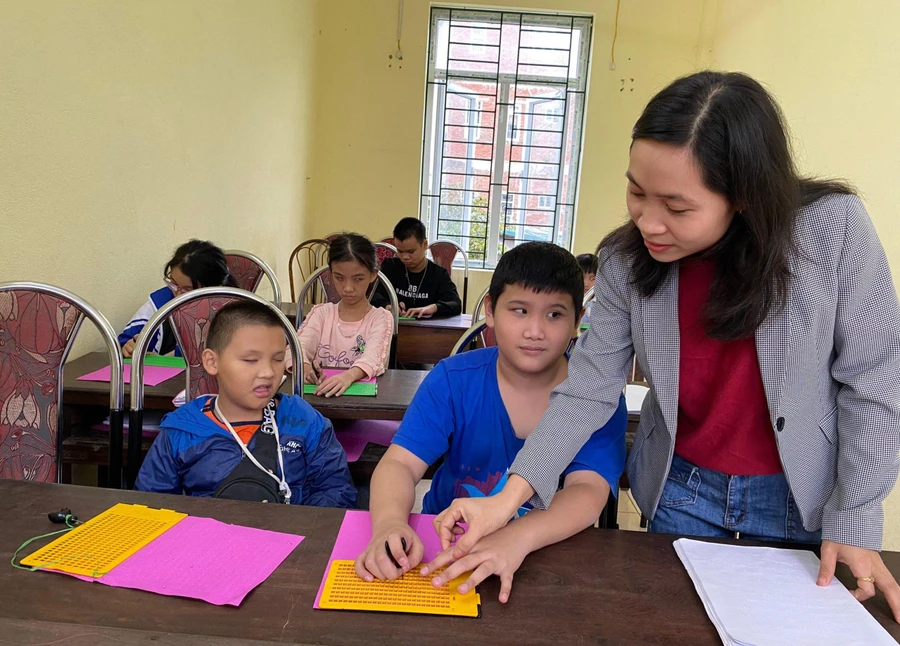 Cô Lương Thị Yến tỉ mỉ dạy học trò cách đọc chữ Braille.