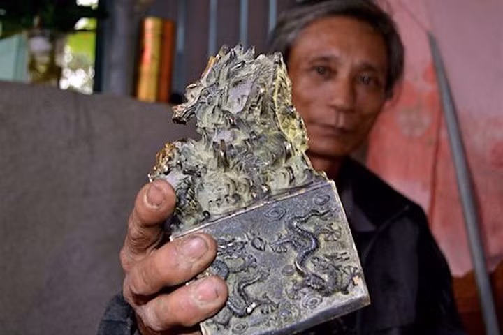 Ông Trương Văn Sửu và vật lạ nghi là ấn tín của vua đào được lúc đi làm đồng. Ảnh: Phạm Hòa