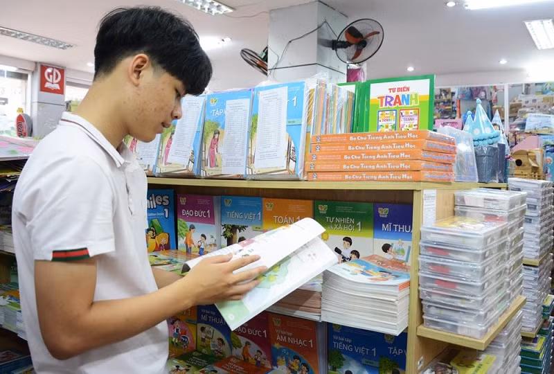 Phụ huynh lựa chọn sách giáo khoa cho con trước thềm năm học mới. Ảnh: IT