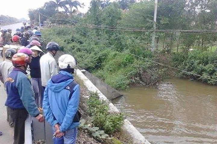 Một nam thanh niên mặc áo mưa, đội mũ bảo hiểm chết dưới mương nước