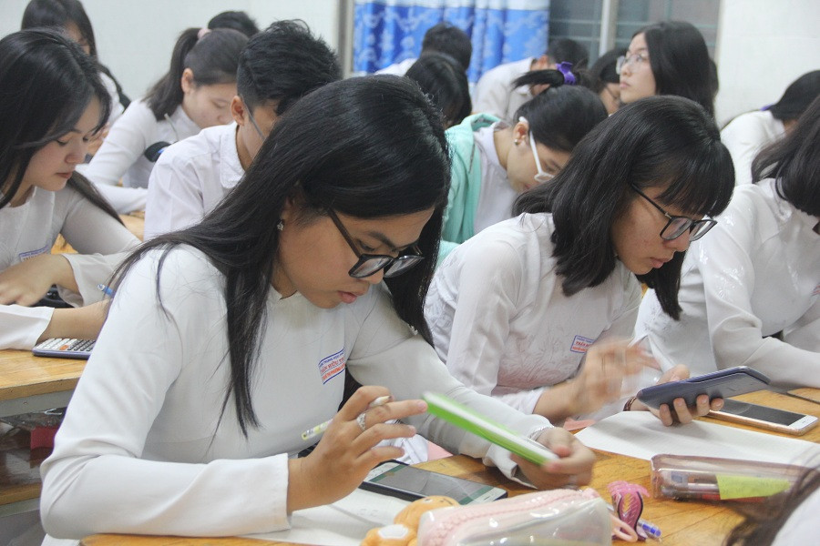 Học sinh chăm chú làm bài thi giữa kỳ trên điện thoại thông minh