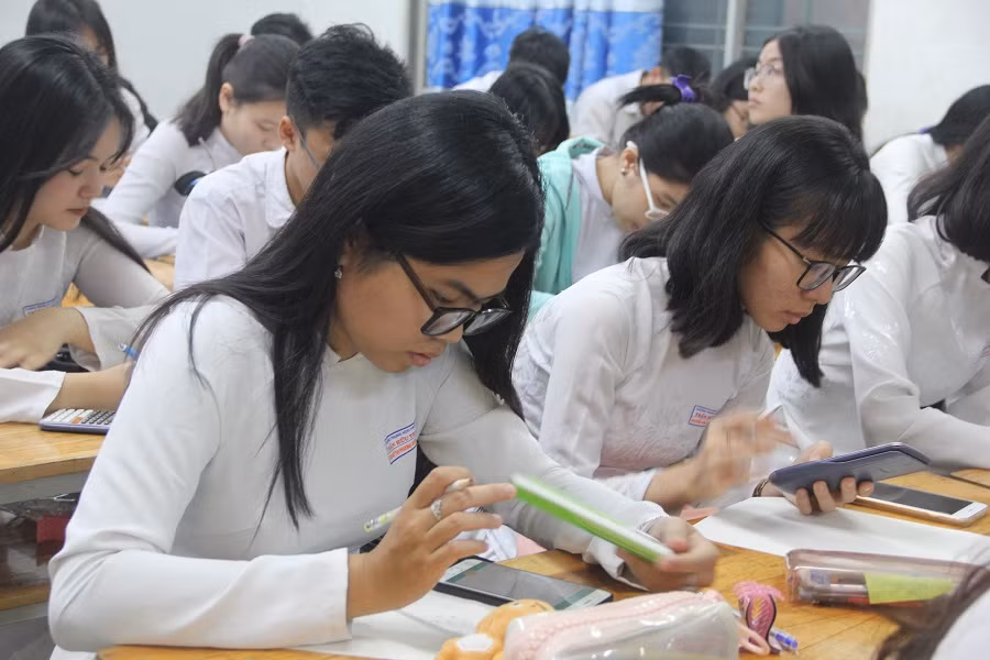 Học sinh chăm chú làm bài thi giữa kỳ trên điện thoại thông minh
