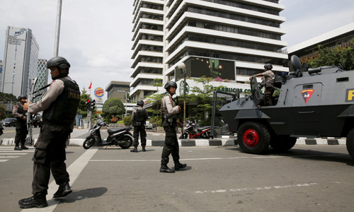 [Caption]policemen with weapons and an armoured vehicle guard in front of a Starbuck cafe at Thamrin business district in Jakarta, January 14, 2016