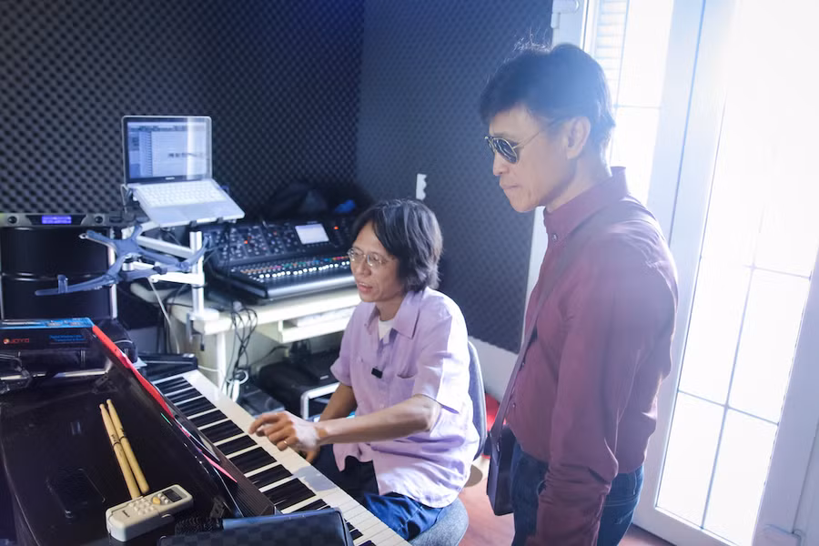 Nguyễn Quang (ngồi) tập nhạc cùng ca sĩ Tuấn Ngọc. Ảnh: BTC