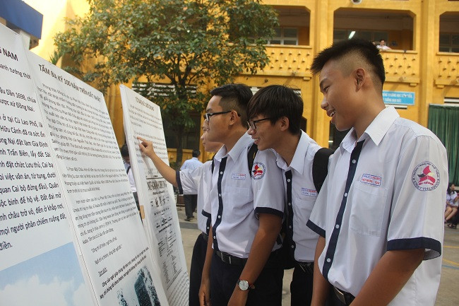Học sinh chăm chú đọc các áp phích do CLB Nghiên cứu và vinh danh văn hóa Nam bộ trưng bày tại sân trường