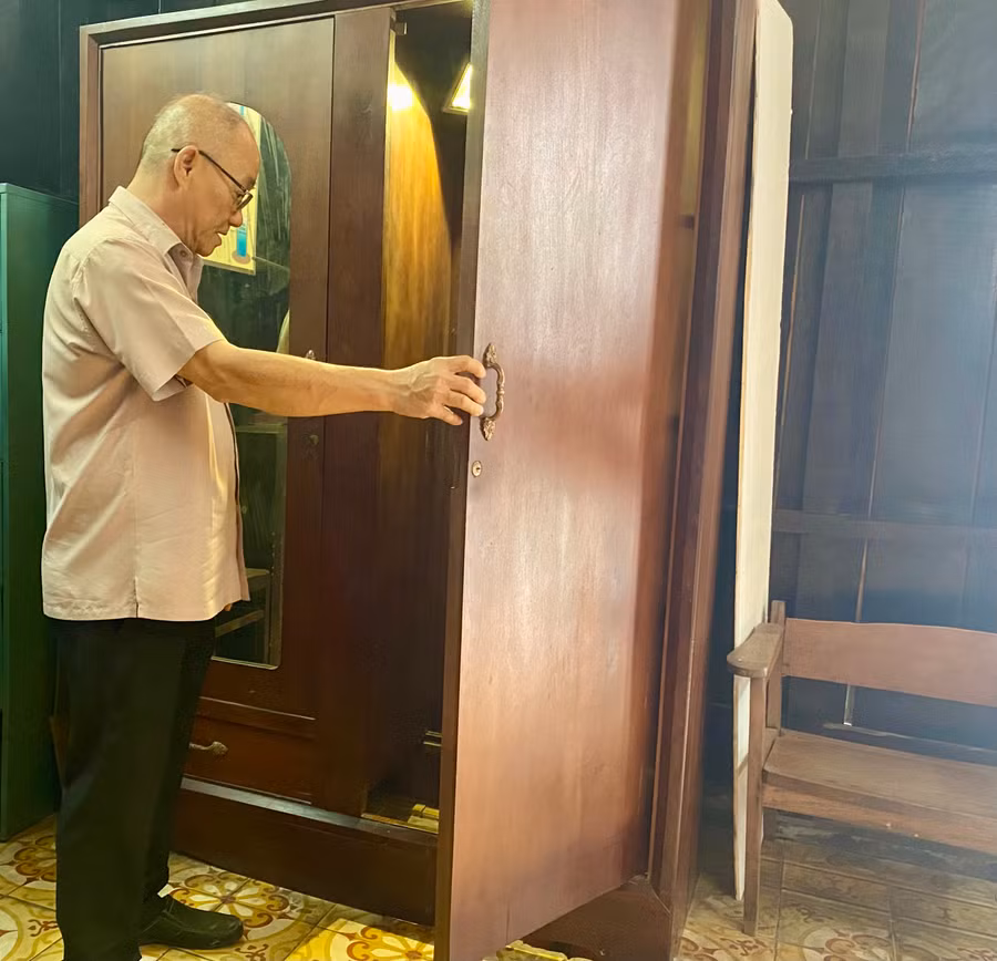 Ông Hồng Lộc, nhân viên quản lý di tích lịch sử, mở cánh cửa tủ dẫn xuống căn hầm dưới lòng đất.