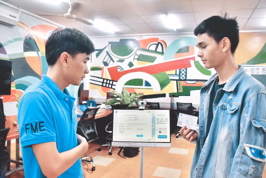 Thành Nam và Xuân Hải (SV Khoa Cơ khí chế tạo máy HCMUTE) quét mã vạch trên thẻ BHYT cho robot nhận diện